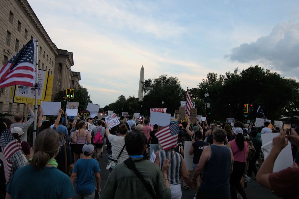 Hundreds of peaceful protesters march from the park to the National Museum of African American History and Culture; the Washington Monument appears in the background