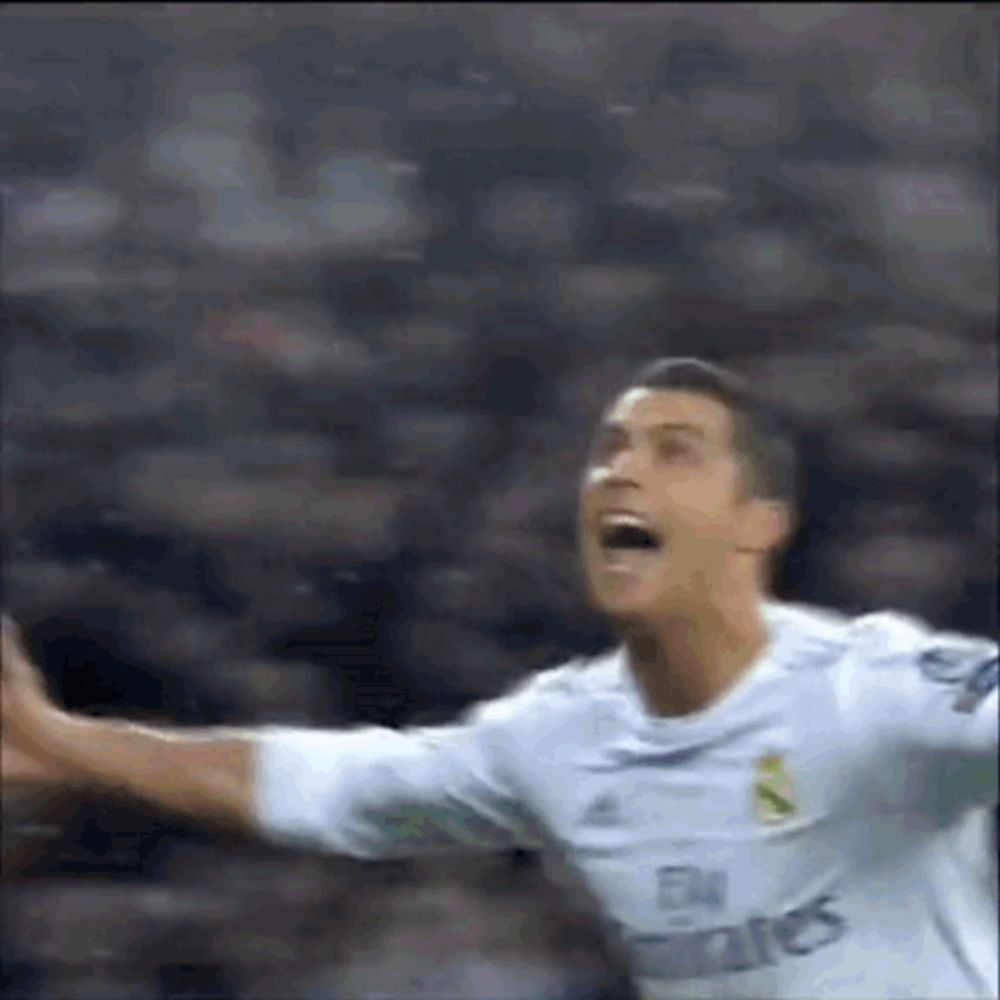 a soccer player is celebrating a goal with his arms outstretched in front of a crowd .