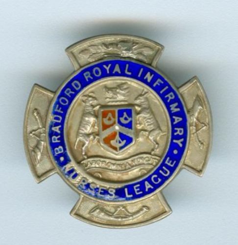Silver and enamel badge, cross with medallion in centre.  the top arm of the cross has a boards head, the other three have a hunting horn.  The outer rim of the medallion is in royal blue enamel with silver inscription 'Bradford Royal Infirmary Nurses League' at the centre the Bradford crest with motto Labor Omnia Vincit-Labour overcomes all things and at centre a shield in red and blue enamel.  I'm not sure what a boar's head has to do with nursing....