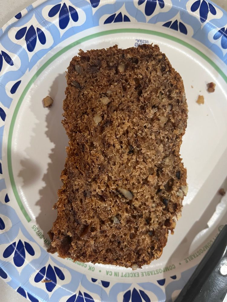 A photo of that same banana bread but this is sliced and resting atop a paper plate. It’s only one slice out of the whole banana bread. 