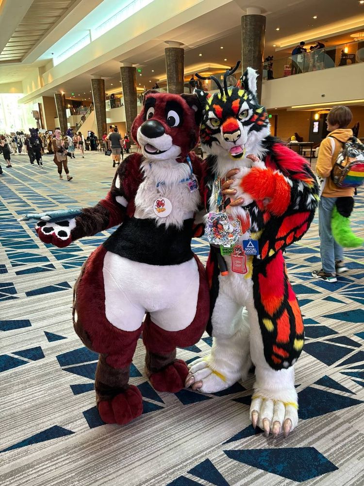 Fursuit photo of tako the otter with a beautiful butterfly-tiger hybrid fursuit 
