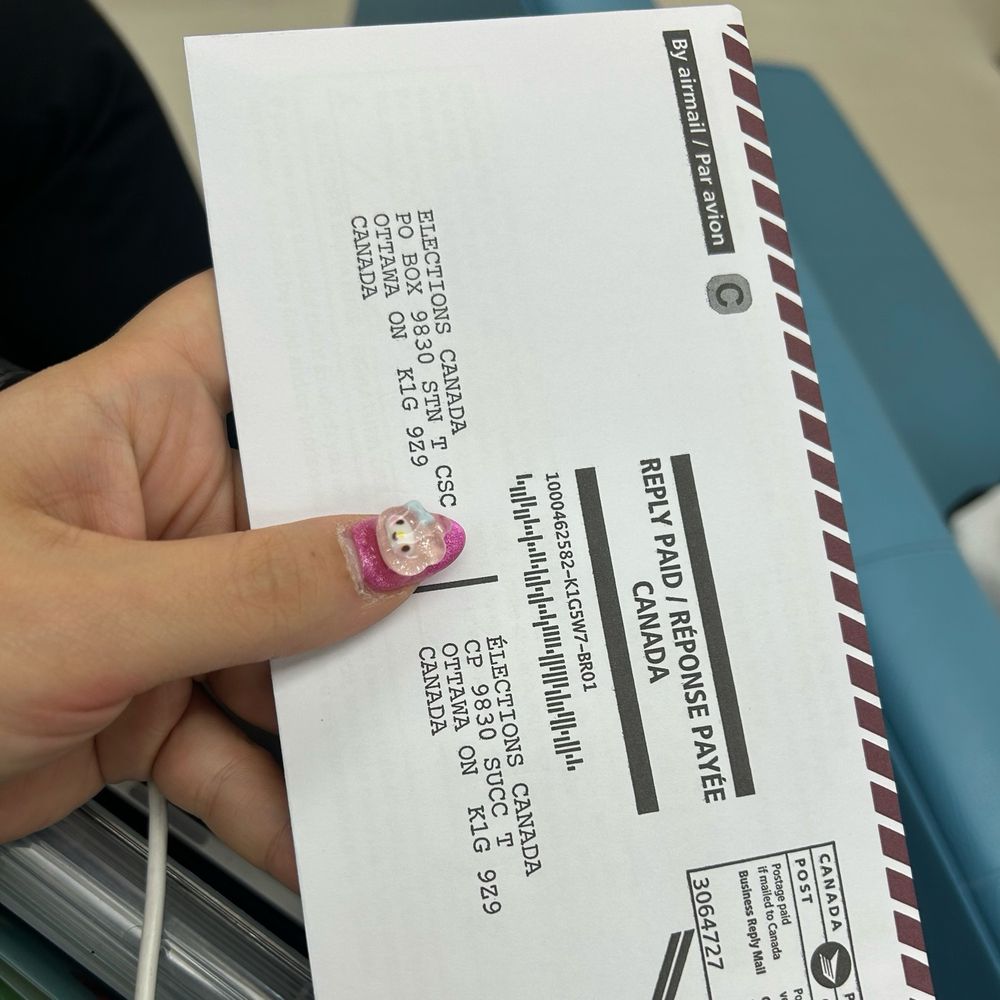 Me holding an envelope for the Canadian election vote-by-mail ballot