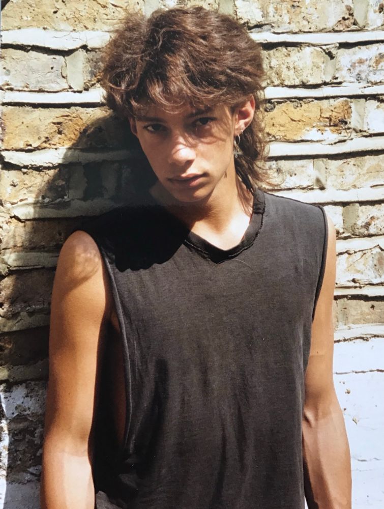 A picture of me at 17, with long hair and skinny arms. 
