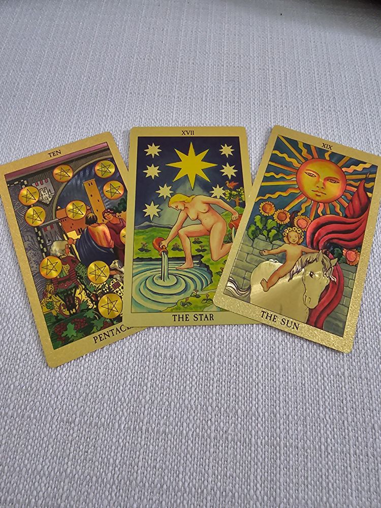 Three tarot cards slipped from the deck as I shuffled. The 10 of Pentacles, The Star, and The Sun.