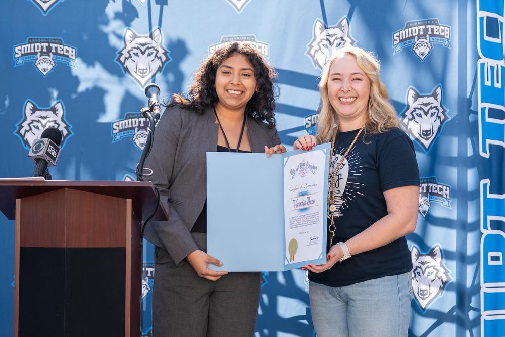 Photo of Elena Chavez (field representative for Councilmember Eunisses Hernandez) presenting Veronica Bane with a city recognition award