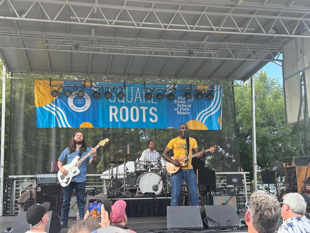 Cedric Burnside onstage at Square Roots Festival playing electric guitar with his band 