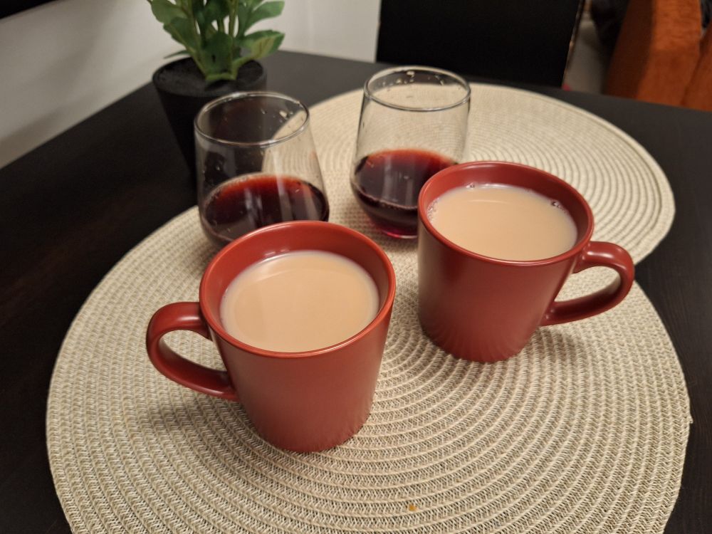 Two glasses of blueberry juice and two proper cuppas