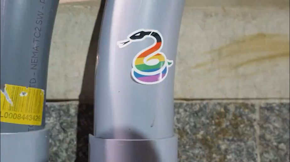 Philadelphia Union alternate logo as a sticker on a pipe. The sticker has the Philly Pride Flag as it's coloring.