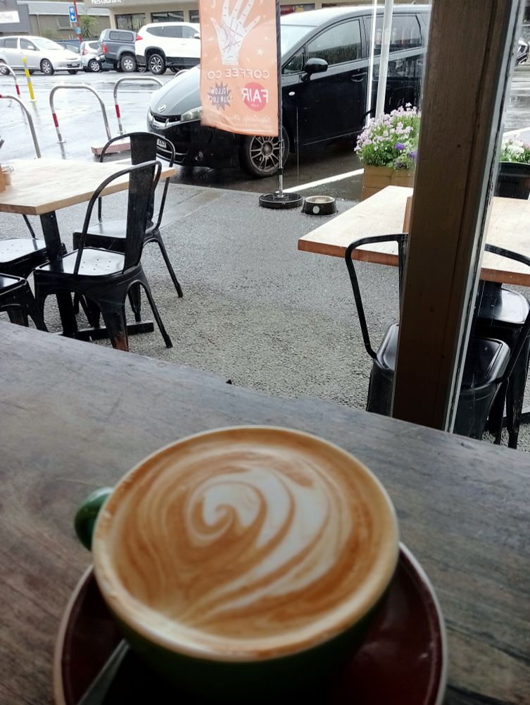 Flat white at a window side table, looking out over a rainy wintery street