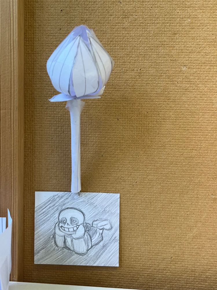 A wide shot of my inspo board where you can see the sans doodle as well as a little flower paper craft
