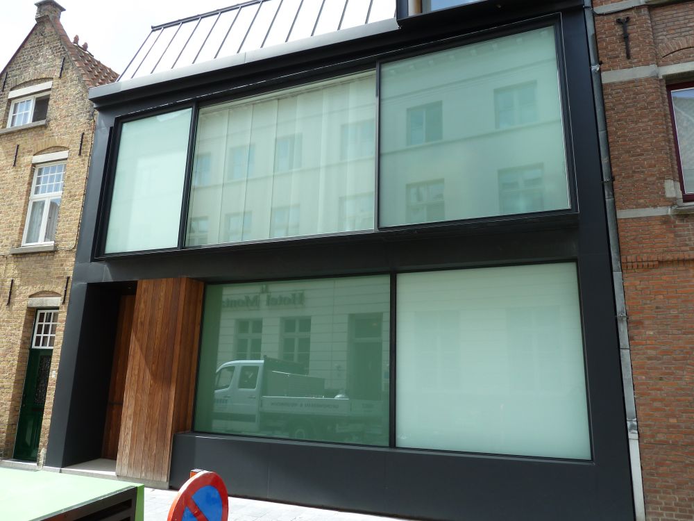 Close-up of a modern terraced house in Bruges nestled between two more traditional houses.