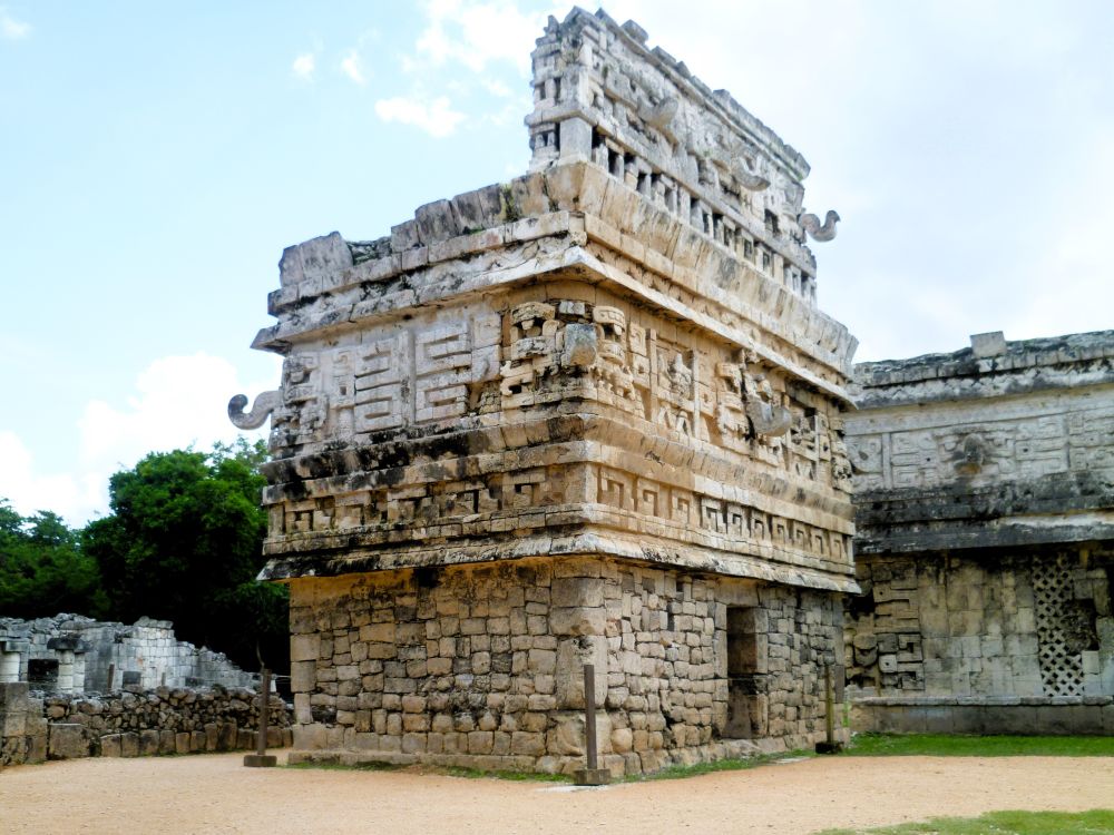 A ruined three storey building with carved stone blocks and projections.