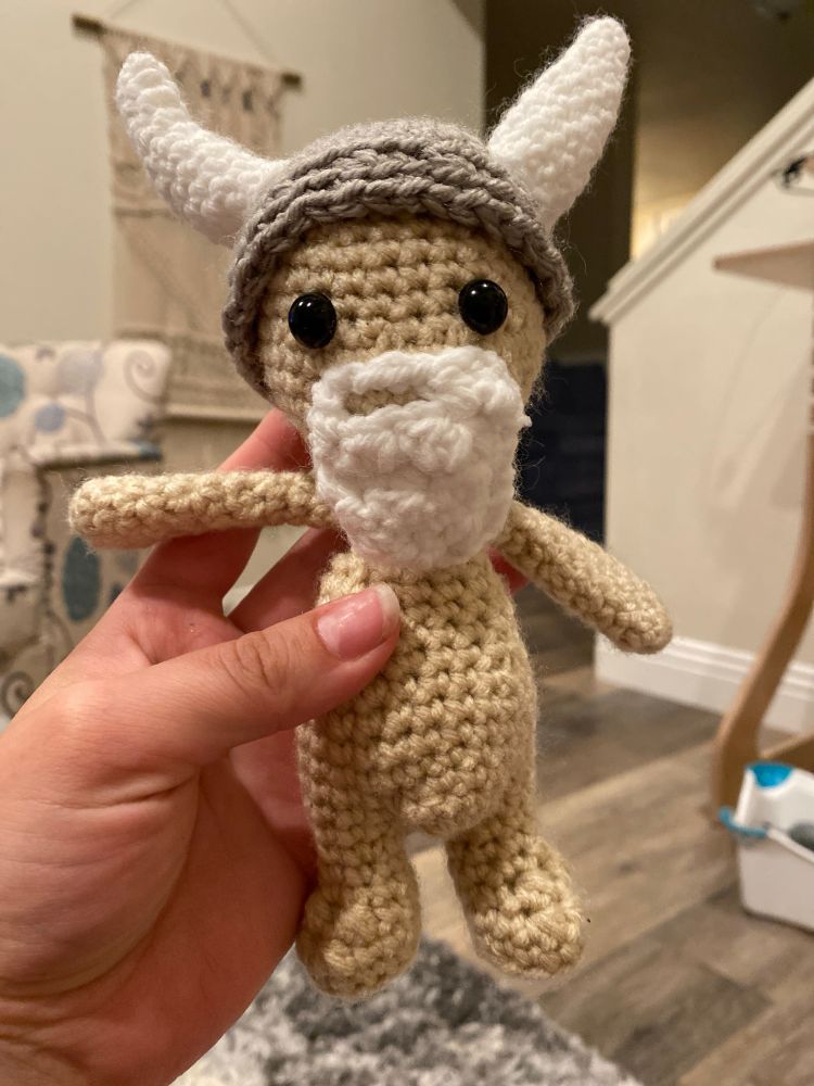 A crocheted Viking man with a white beard