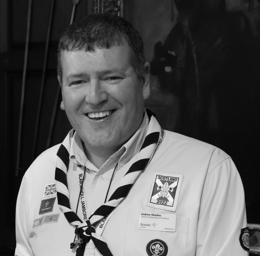 Black and white photo of Sharkey, smiling at the camera, wearing his Scout Uniform