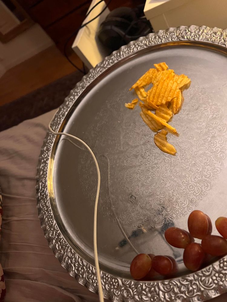 Bricka med vindruvor och chips på.