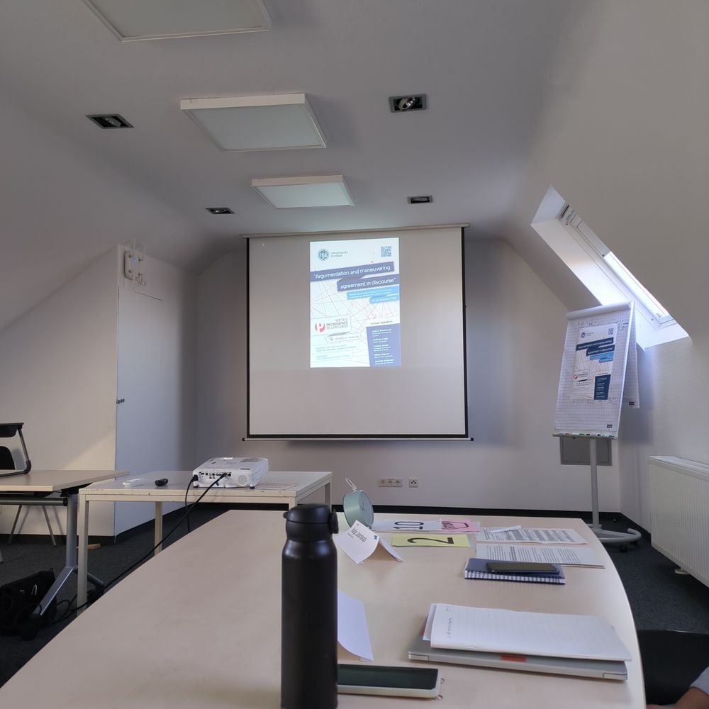 the projector screen of a conference room, displaying the workshop on argumentation flyer