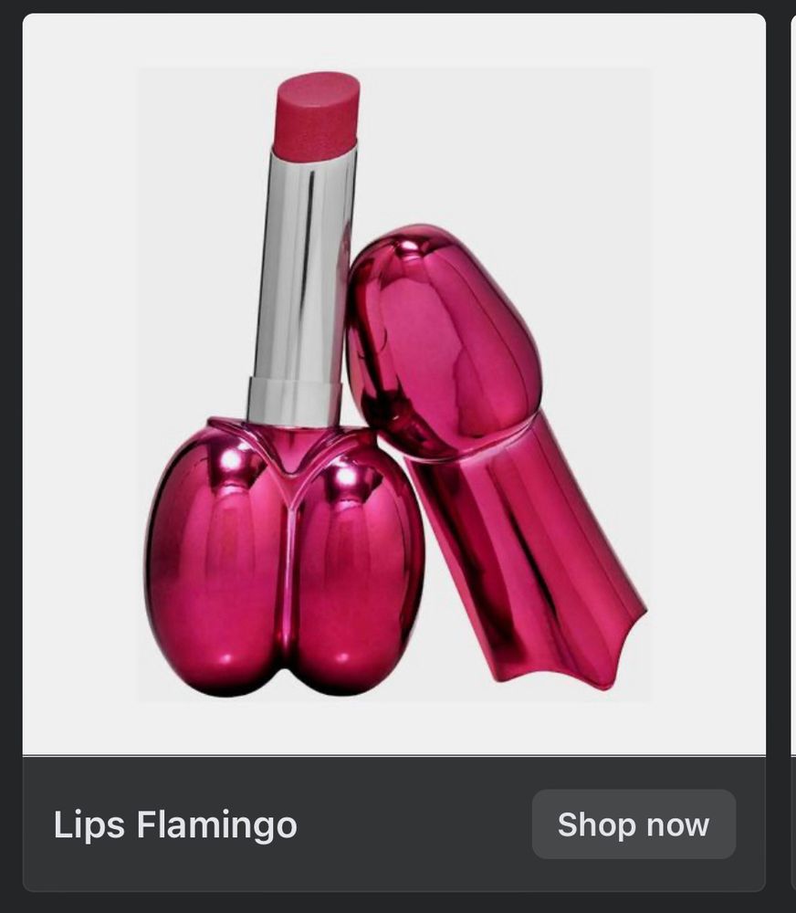 Image of metallic lipstick, uncapped. Base of lipstick is shaped like two hot pink chrome eggs, and the cap… well, it’s shaped like a hot pink narrow unopened mushroom, or … a type of object where the shaft also has a head.