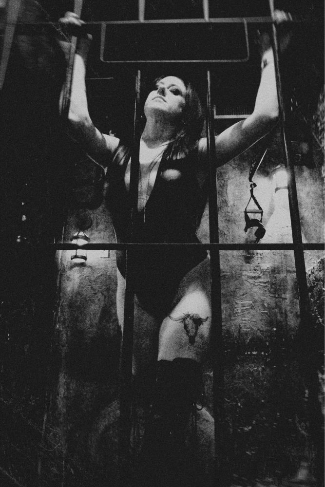 a black and white, grayscale photograph of mistress olivia snow in the nyc dungeon pandora’s box. shot in new york city.