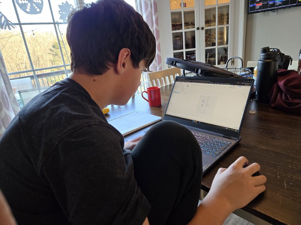 A boy sitting at a computer learning 3D CAD.