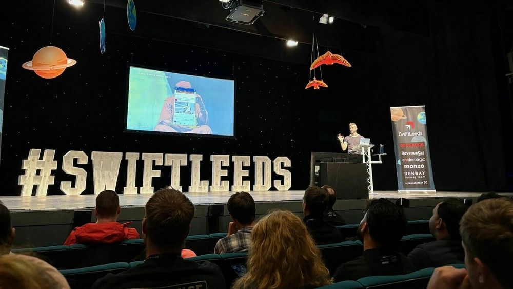 Photo of Sash on stage at the conference.