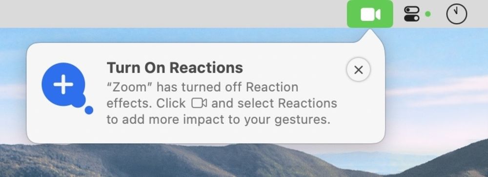 Screenshot of end of Mac menu bar. Popup from camera icon says “Turn On Reactions: Zoom has turned off Reaction effects. Click camera icon and select Reactions to add more impact to your gestures.”