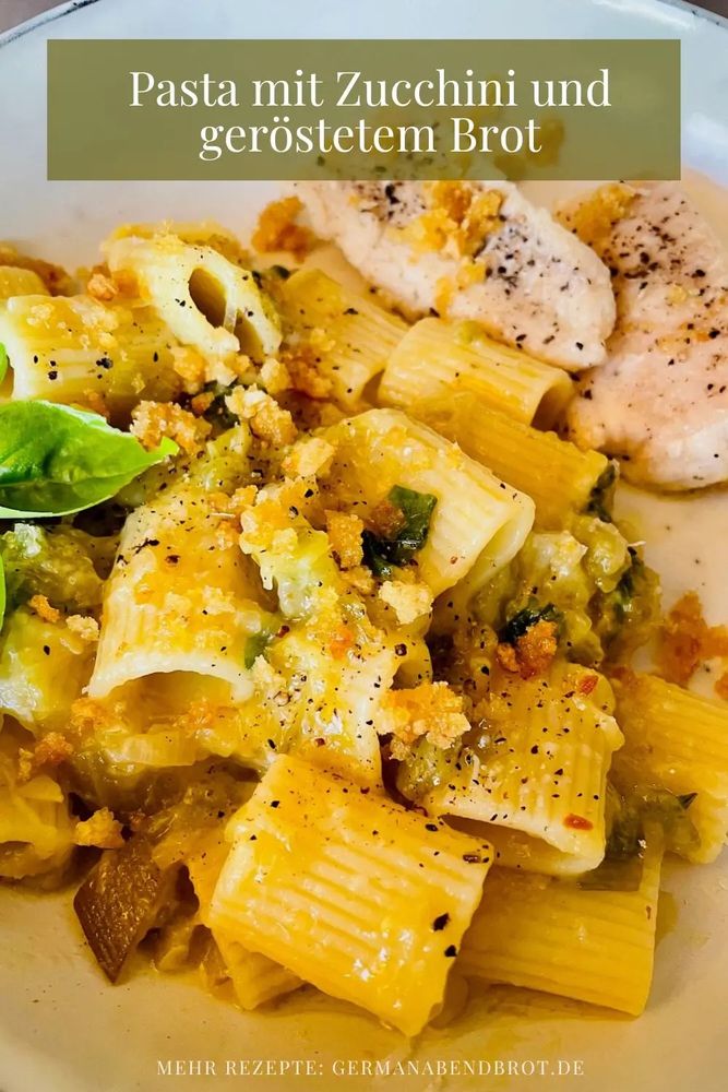 Kurze Röhrennudeln mit Zucchini, Basilikum, Brotkrumen, im Hintergrund Fischfilet.