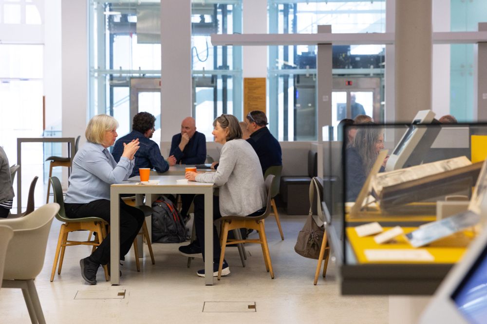 People sit around a table in a library talking.