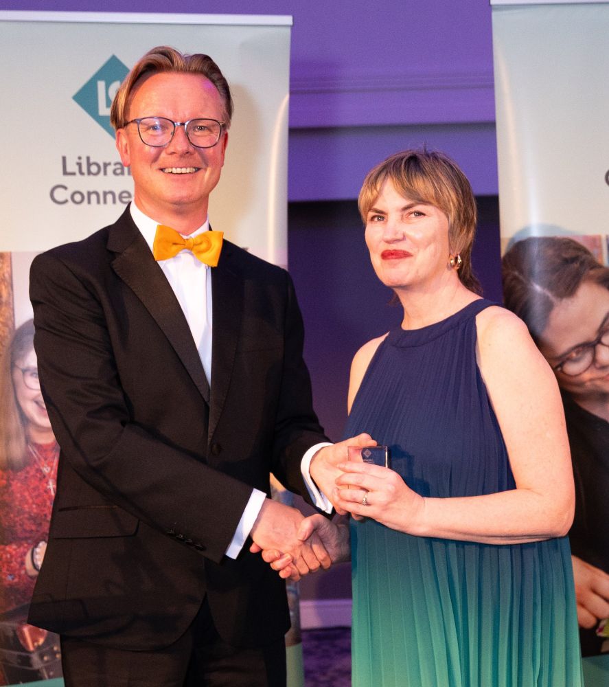 Libraries Connected President Ed Jewell photographed at the Libraries Connected Awards. He is wearing a black suit and orange bowtie.