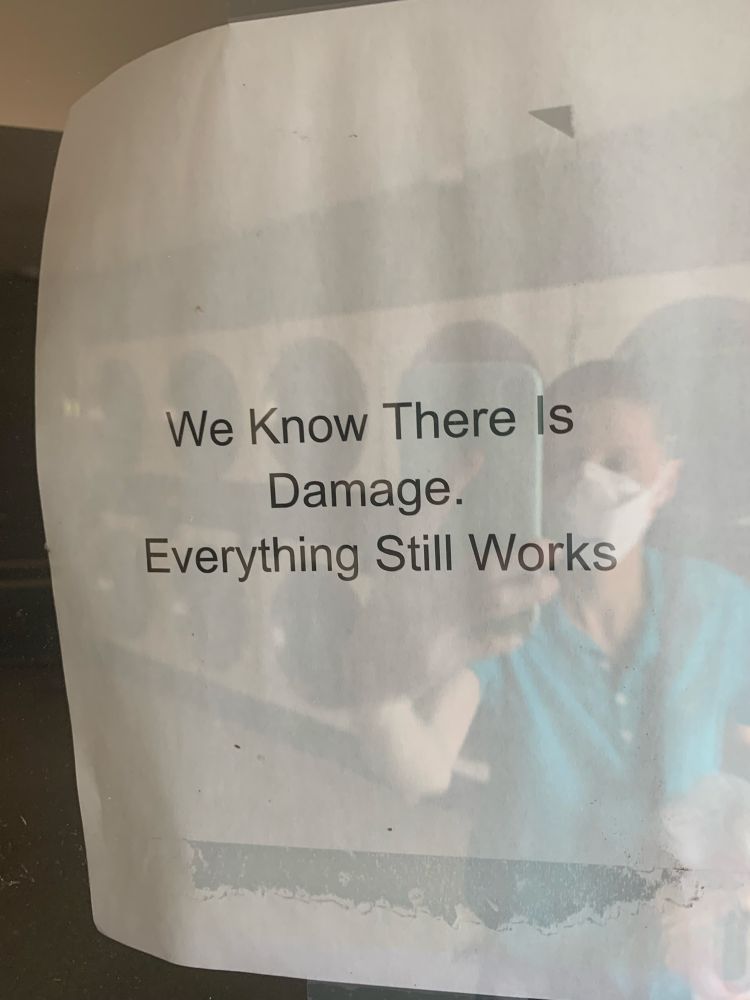 A photo of a paper sign that says “We know there is damage. Everything still works.” 