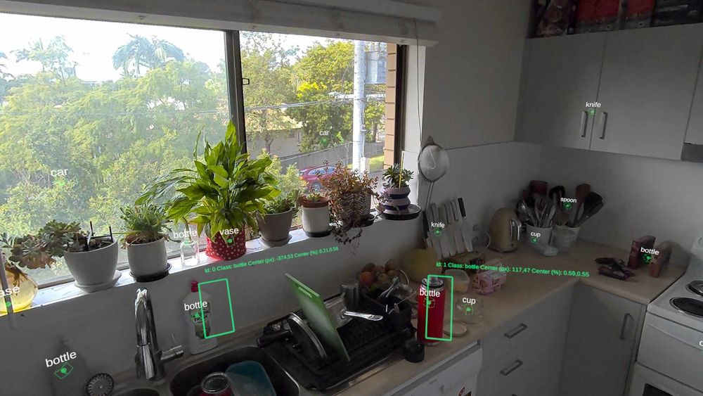 A screenshot of a kitchen through a vr headset. Objects contained in green bounding boxes with AI text descriptions attached.