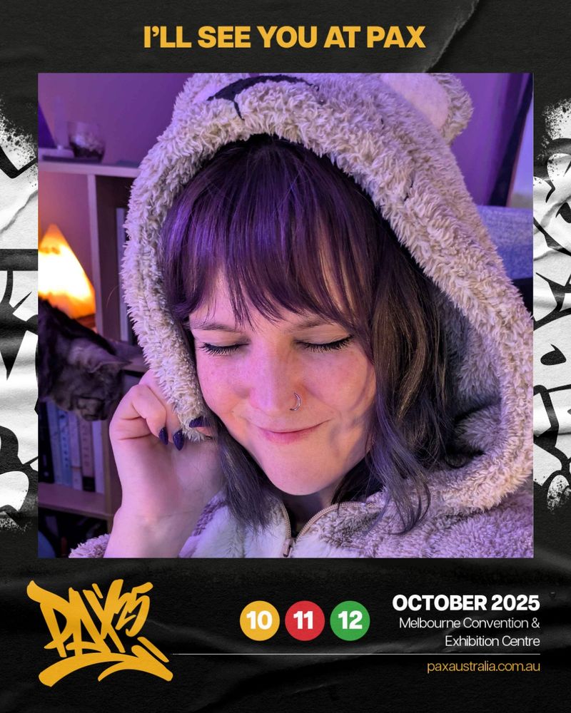 This is a PAX Aus 2025 announcement graphic. It features a photo of Peets in the middle. She is smiling with her eyes closed. She is wearing a cosy teddy bear onesie. Her hair is purple and she has a nose ring. There is a cat in the background.
The photo is surrounded by a black border. There is yellow text saying "I'll see you at PAX" at the top, and a yellow PAX 25 logo in the bottom left. It also lists the dates (October 10-12th 2025), the location (Melbourne Convention & Exhibition Centre), and the PAX website to find out more (paxaustralia.com.au).