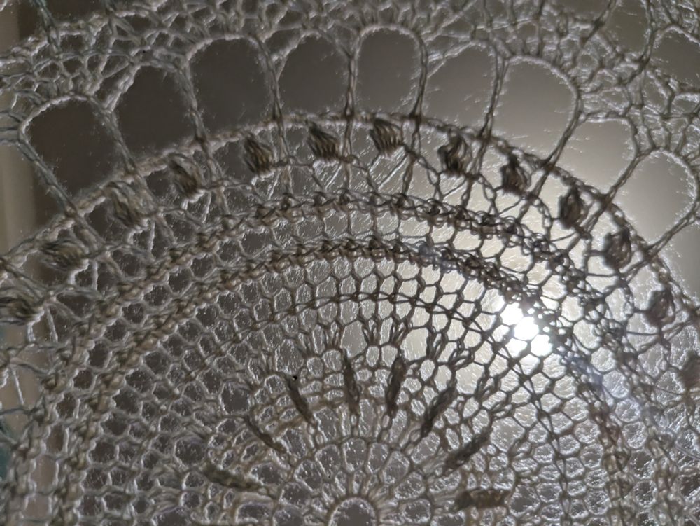 A photo of a crocheted doily in super fine silk.