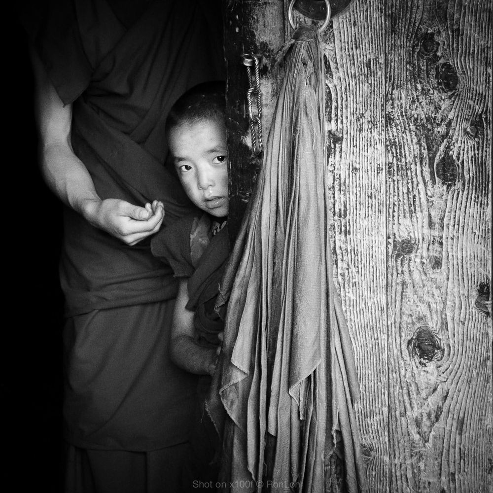 Young monk peeking out of the door