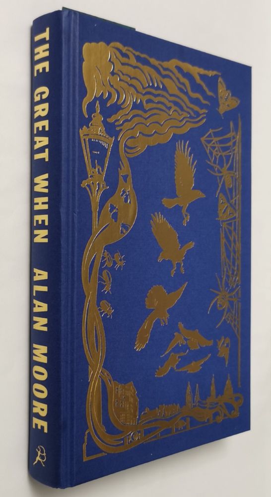 Photograph of a hardcover copy of the novel The Great When, written by Alan Moore. The dust jacket has been removed to show the blue binding and gold coloured title/author text on the spine, and also there are some silhouettes of birds (mostly corvids) flying about an impression of a Londonesque landscape on the front cover.