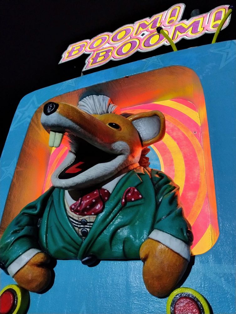 A photograph of a model of Basil Brush wearing his trademark green suit jacket with the words "BOOM! BOOM!" above.
