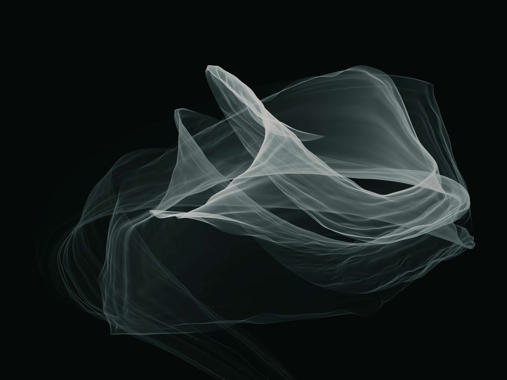 A ghostlike image of swirling paths moving through space and overlapping one another, in a similar but not identical pattern. Grayish-blue against a black background.