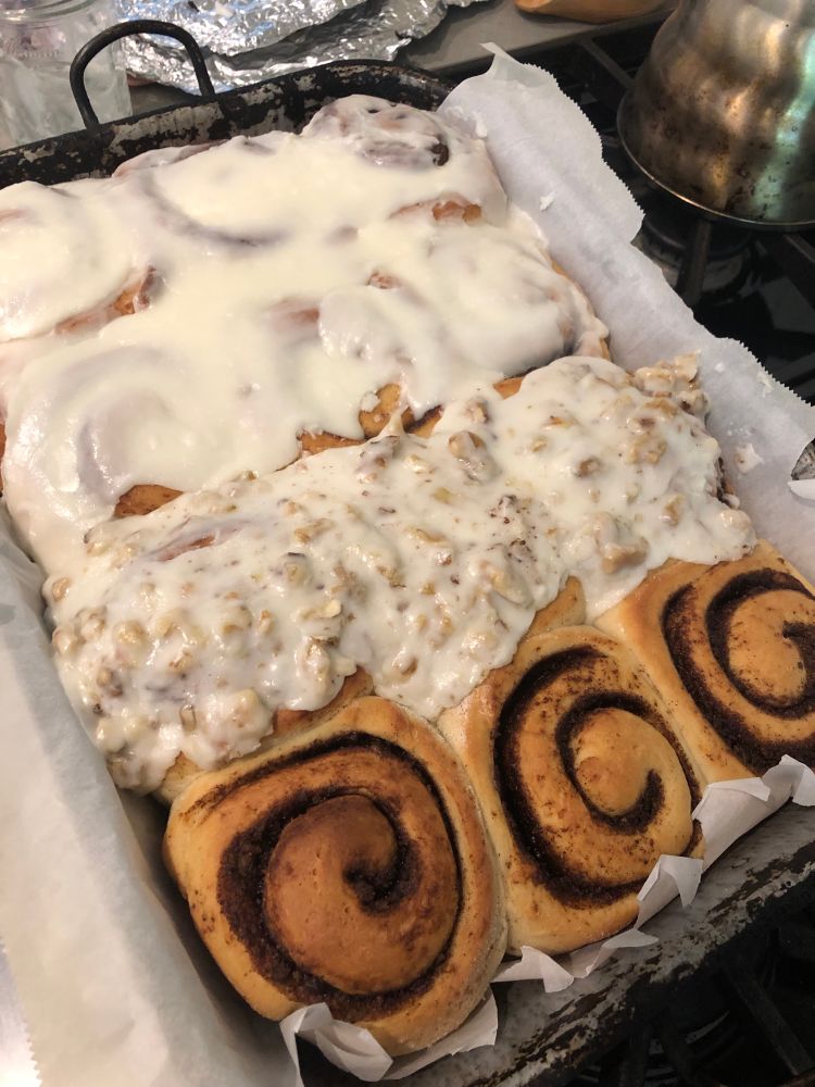 Baked cinnamon rolls with various toppings.