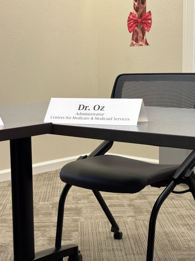 A photo of an empty chair. In front of it is a name card that reads Dr. Oz, administrator for Centers for Medicare and Medicaid Services.