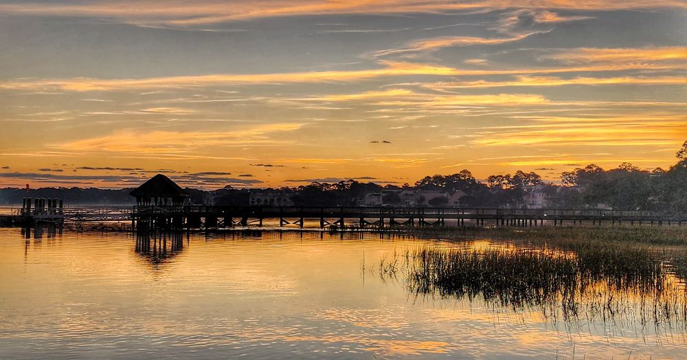 View of ferry dock just before sunrise with orange skies