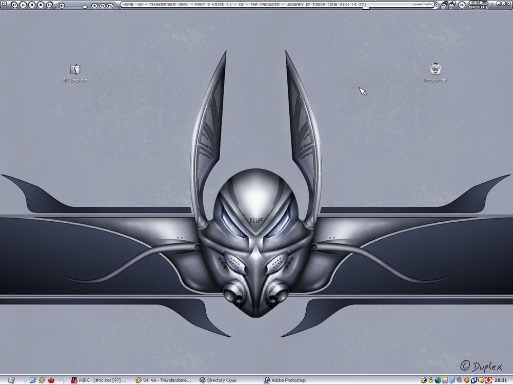 Windows 2000 era screenshot of a customized themed desktop using a lot of muted blues and chromed greys. Winamp, mIRC, and Adobe Photoshop are visible on the taskbar.