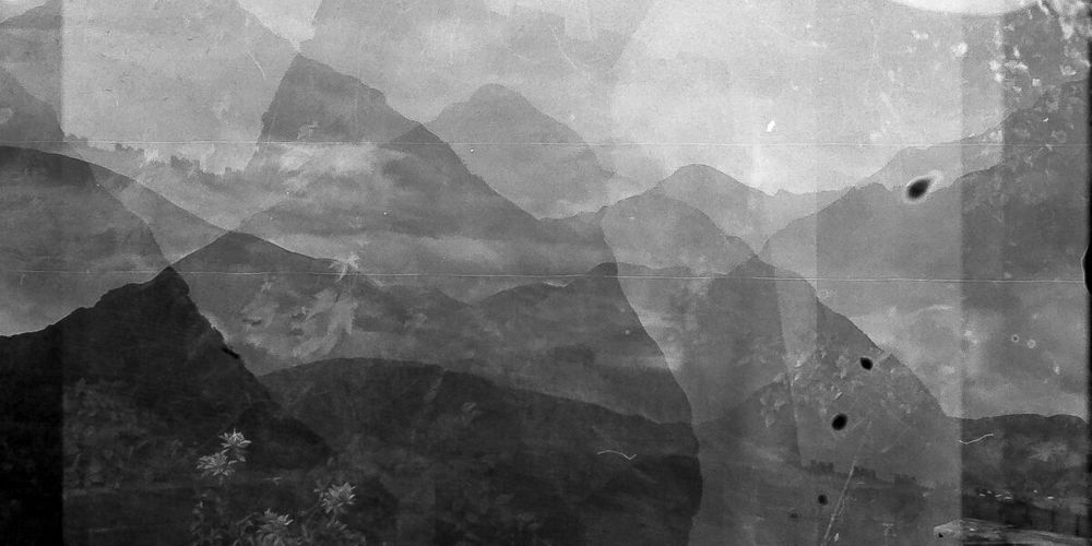 Greyscale overlaid image of moody looking mountain landscapes