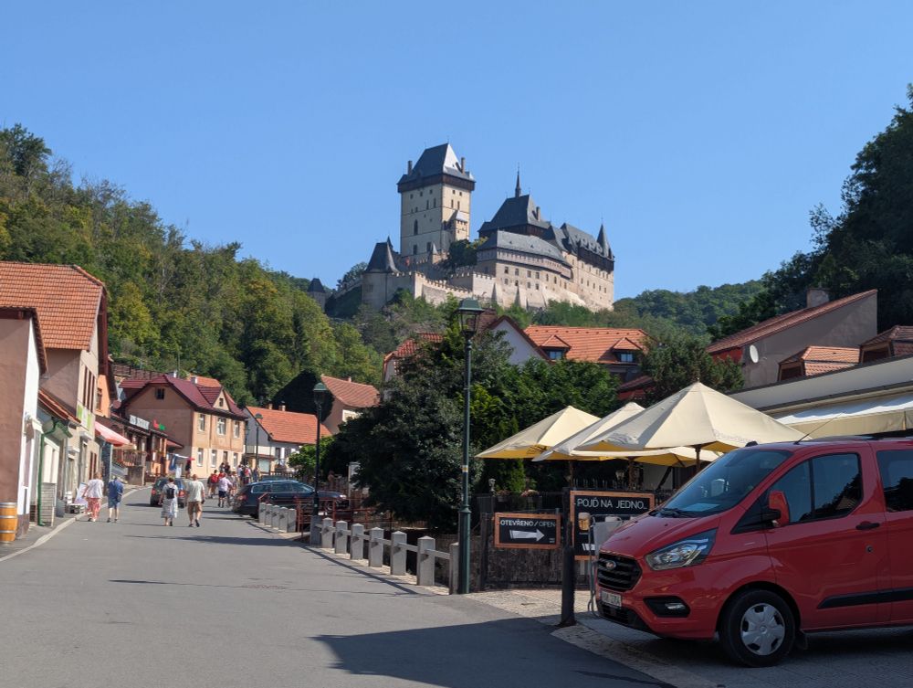 A pristine fairytale gothic castle proud above small red-roofed houses and all under a perfect blue sky.