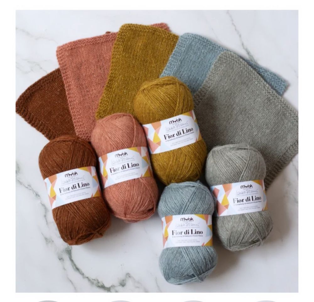 Five skeins of yarn and a knitted swatch of each. Fox, peach, gold, a pale blue and a sea foam green. (These are not the actual names of the colorways.)