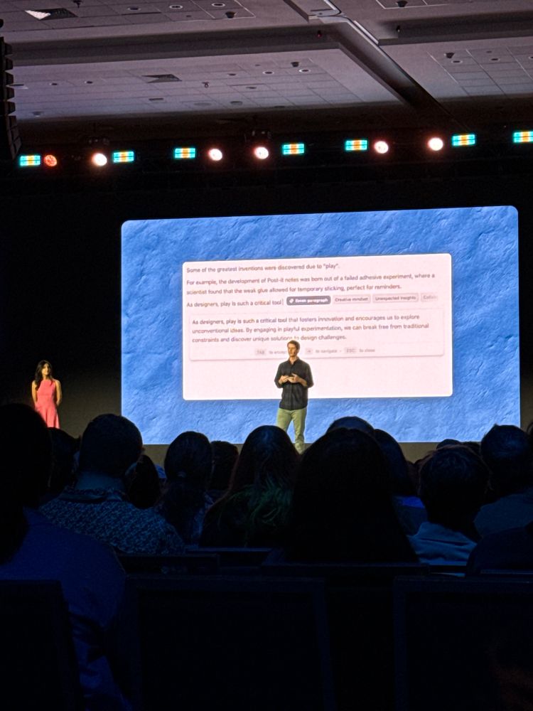 A speaker with a video demonstration of grammarly in the background