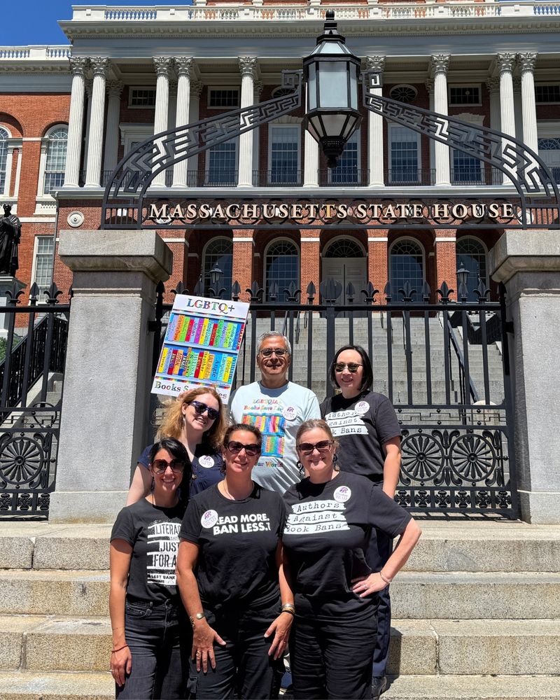 Members of Massachusetts Authors Against Book Bans are standing on the steps in front of the gate to the Massachusetts State House. Clockwise from top left: Tui Sutherland, Federico Erebia, Malinda Lo, Michelle Cusolito, Dana Alison Levy, and Amanda Davis