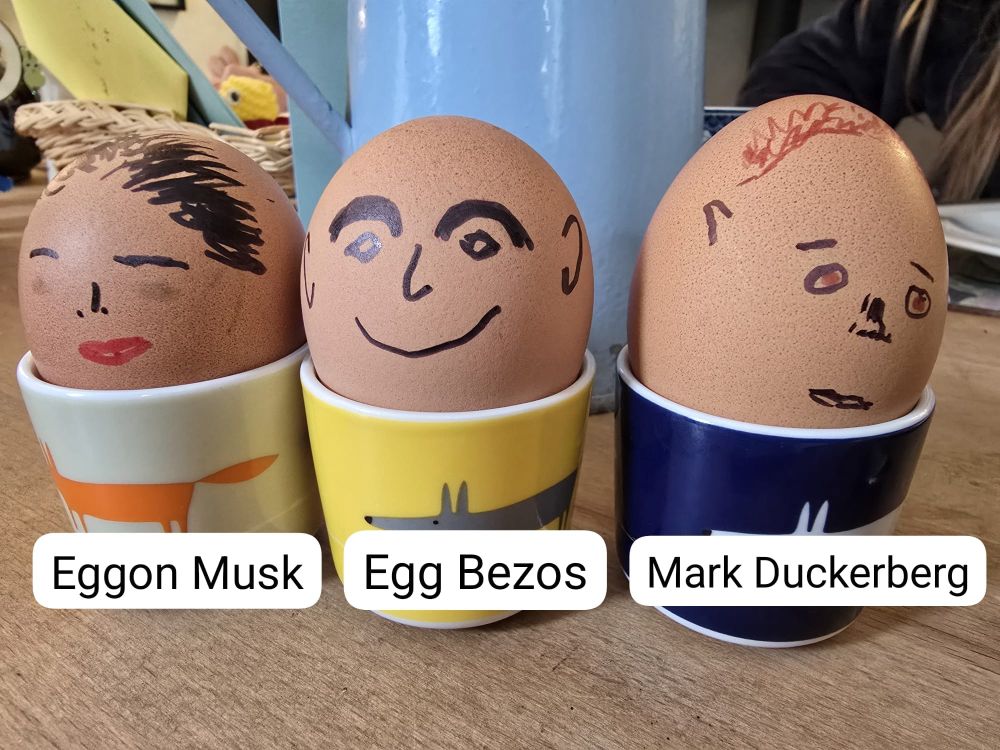 Three boiled eggs decorated like billionaires 