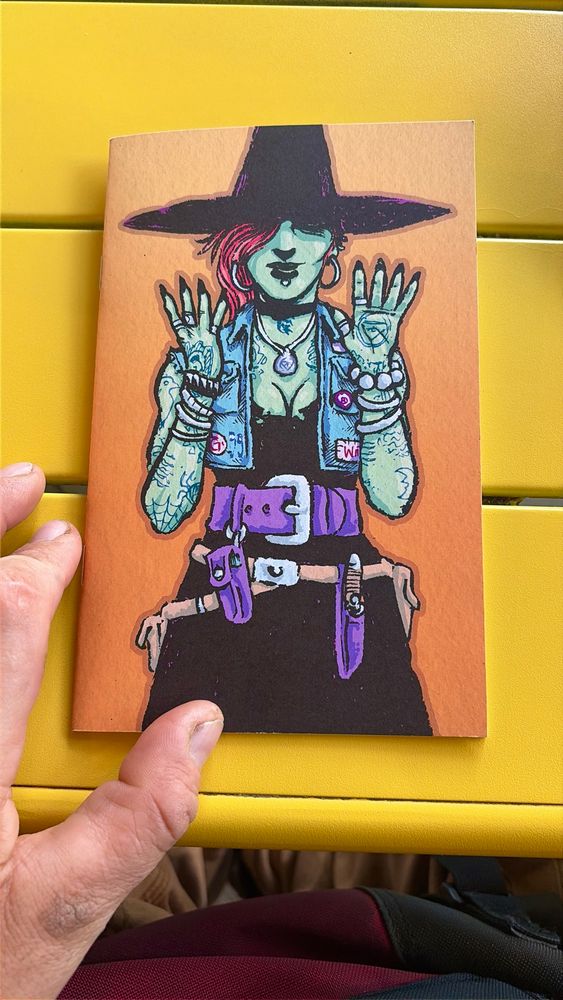 A colorful photo of a zine with a witch on the cover.