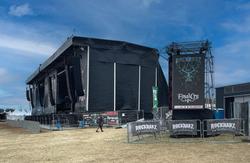 Foto von der Bühne des ROCKHARZ, seitliche perspektive - blauer Himmel. Davor eine LED Wand mit der Ankündigung für das nächste Jahr "ROCKHARZ 2026 - FINAL CRY