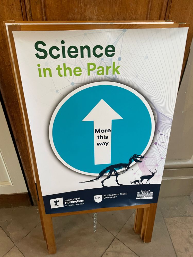 Sign for Science in the park, a blue circle with a white arrow with text saying ‘More this way’