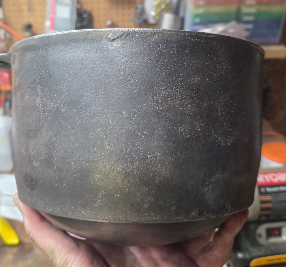 Side view of a bare cast iron cauldron